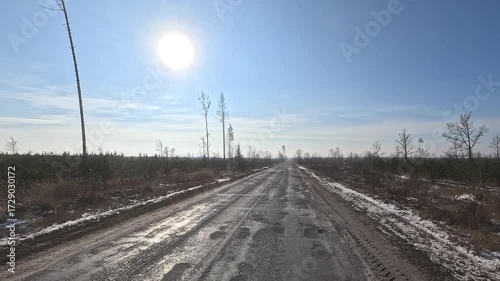 Winter road with snow, highway with cars on a sunny winter day. Winter landscape, road and shoulder covered with snow.