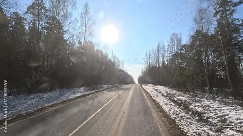 Winter road with snow, highway with cars on a sunny winter day. Winter landscape, road and shoulder covered with snow.