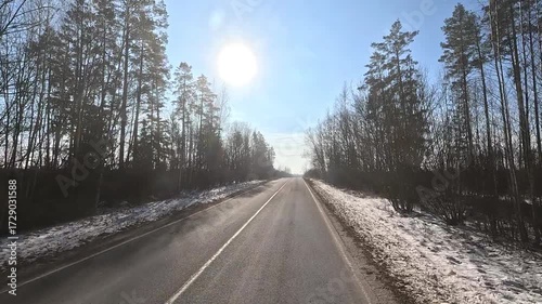Winter road with snow, highway with cars on a sunny winter day. Winter landscape, road and shoulder covered with snow.