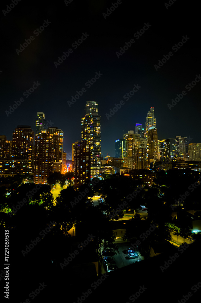 Obraz premium Stunning night skyline view of a vibrant urban landscape filled with sparkling lights and towering skyscrapers