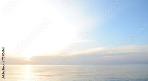 Calm ocean scene with pastel blue sky at golden sunrise or sunset