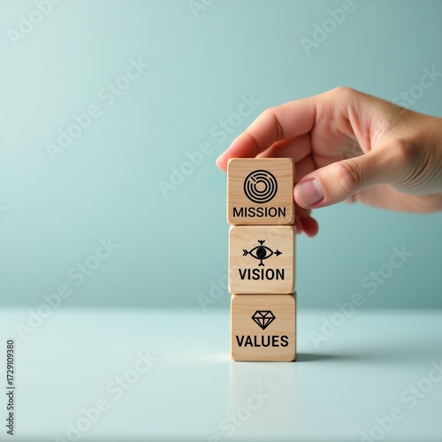 Business strategy concept with hand stacking wooden blocks showing mission, vision, and values for corporate culture.