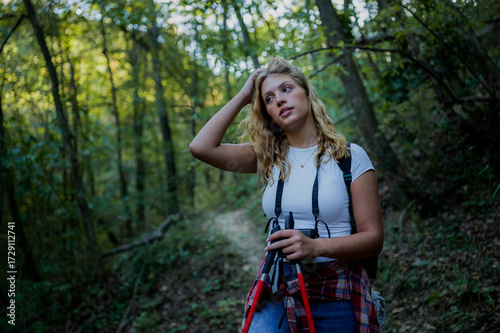 Bild auf Leinwand Woman hiking in forest pausing contemplating nature path