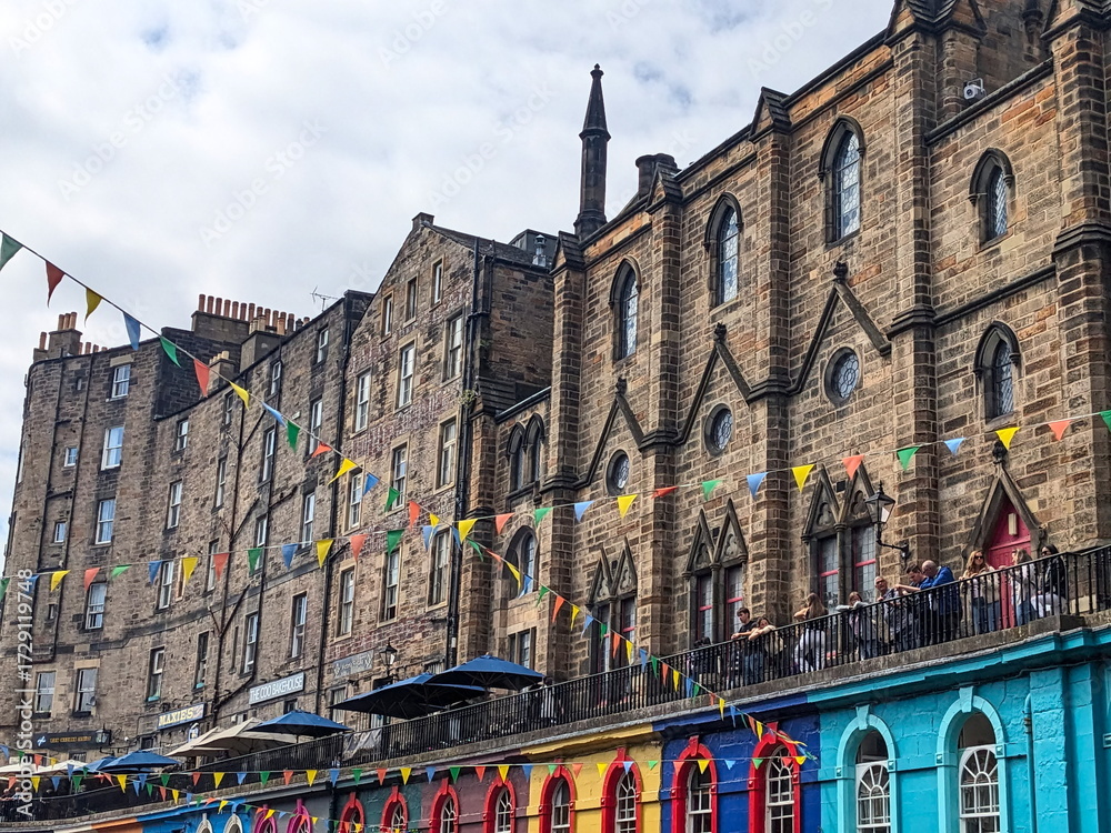 Fototapeta premium Festive bunting hangs over the vibrant, colourful shops of historic Victoria Street in Edinburgh