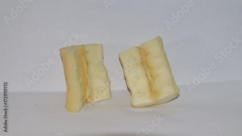 Tableau sur toile Two pieces of cassava root sit on white surface, showing its starchy texture and natural color in a simple studio shot