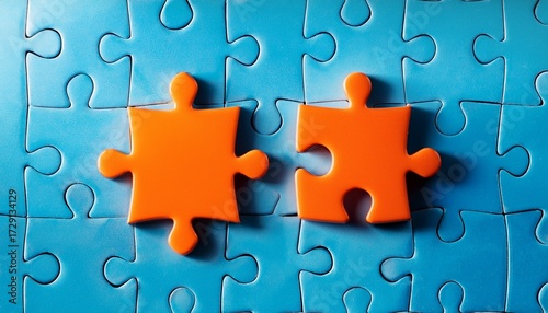 two orange puzzle pieces fit together on a blue background of other puzzle pieces