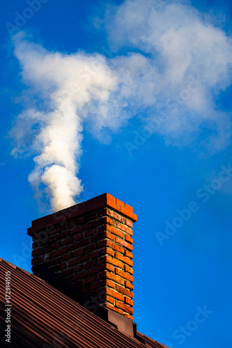 Smoke from the chimney of a single-family house