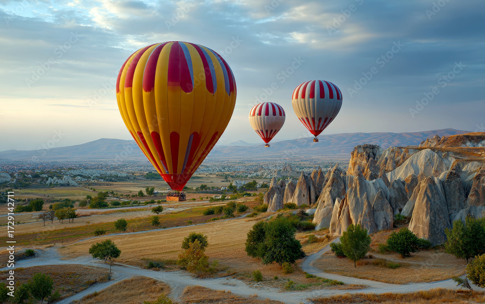 Obraz premium Hot air balloons soar over the surreal landscape of Cappadocia, Turkey, during the golden hour.