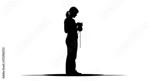 Focused woman silhouetted while intently crocheting yarn, capturing quiet creativity and handmade craft