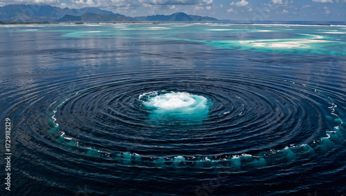 Ocean whirlpool with distant islands and mountains