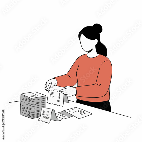 Woman organizing receipts while standing at a table in a workspace  