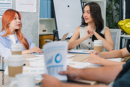 Business people engage in casual hackathon meeting, cross-department discussion sharing fresh ideas in a small office, building teamwork and collaboration toward common goals and success
