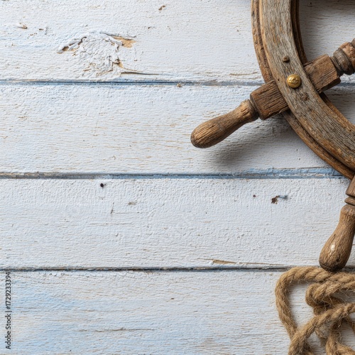 A weathered wooden ship's wheel rests on a distressed, light-blue-toned white wood plank surface, with a nautical rope in the bottom right corner, showcasing a tranquil and vintage nautical theme.