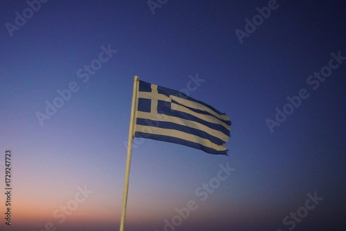 Greek flag on the sky during sunset