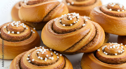 Traditional Swedish cinnamon buns with rich swirls and pearl sugar topping, isolated on white