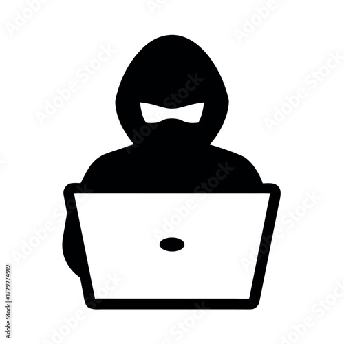 Silhouette of a hooded figure using a laptop computer representing cybercrime and online security threats