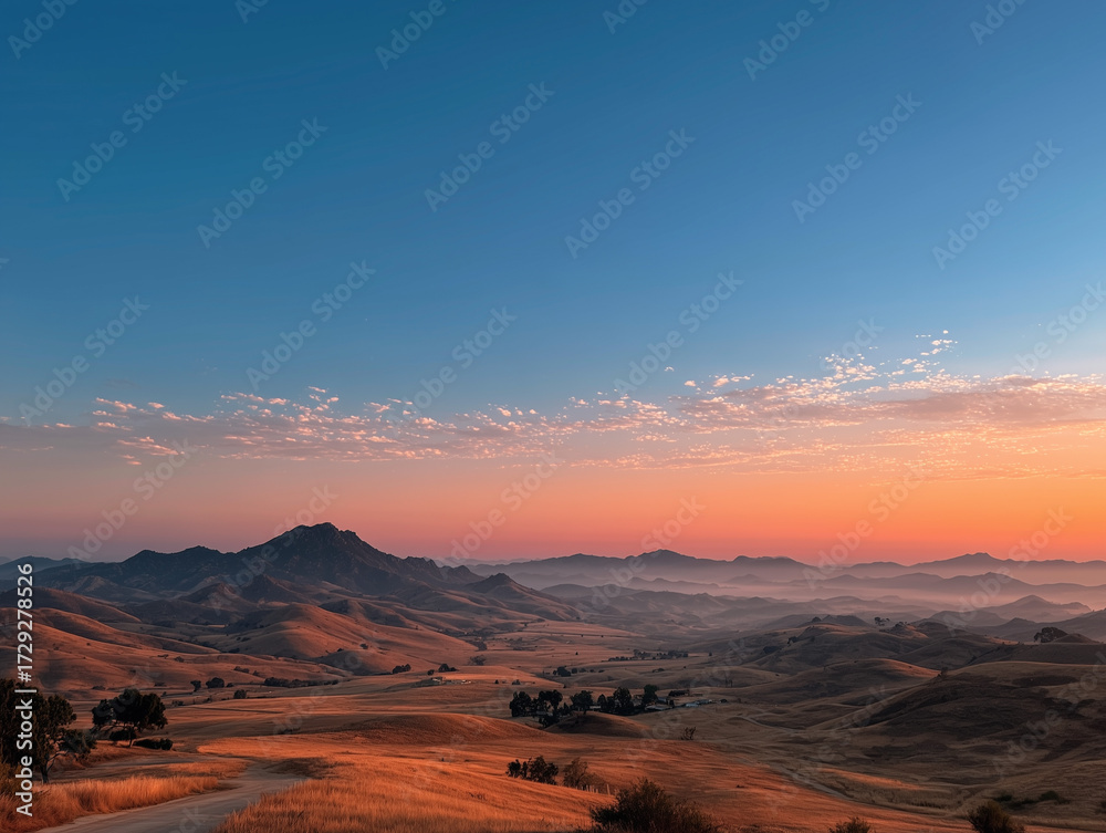 Naklejka premium Golden Hour Over Rolling Hills and Distant Mountains