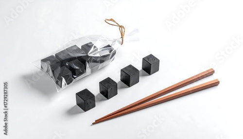 Dark cubes in clear plastic bag with wooden chopsticks