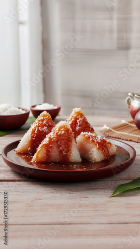 Authentic Lopis (Lupis) Indonesian sticky rice cake dessert on a wooden table, drenched in thick, sweet palm sugar syrup (gula merah/gula jawa) and topped with fresh grated coconut.	