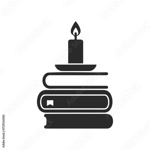 Silhouette of a candle on stacked books for cozy reading ambiance
