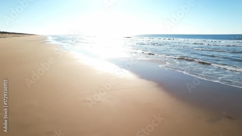 High tide timelapse on a sandy beach, showing the ocean slowly advancing and receding over the expansive shore sandy beach, sky, environment