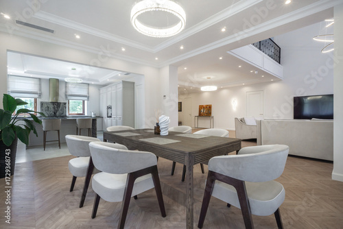 Wallpaper Mural The dining area features a spacious table surrounded by white chairs, illuminated by modern lighting fixtures. Large windows enhance the bright atmosphere, showcasing a contemporary design Torontodigital.ca