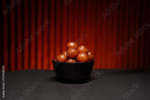 A bowl full of gulab jamun in sugar syrup pool, luxury dessert