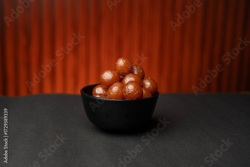 A bowl full of gulab jamun in sugar syrup pool, luxury dessert