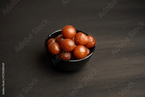 A Gulab jamun in sugar syrup pool, luxury dessert