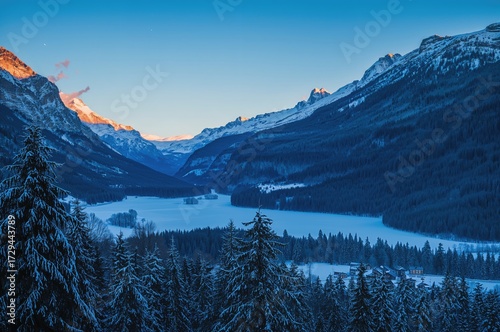 Twilight in a snowy mountain valley overlooking a lake