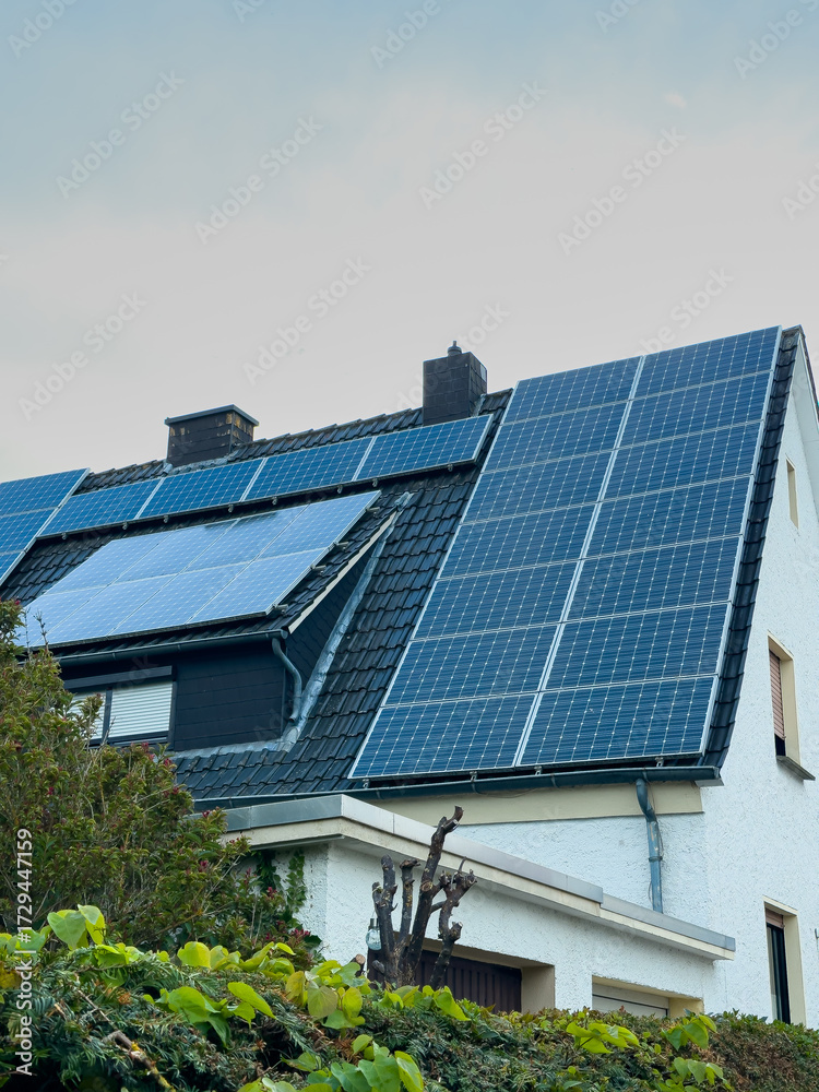 Fototapeta premium Solar panels installed on a modern house roof in a residential area showcasing renewable energy solutions