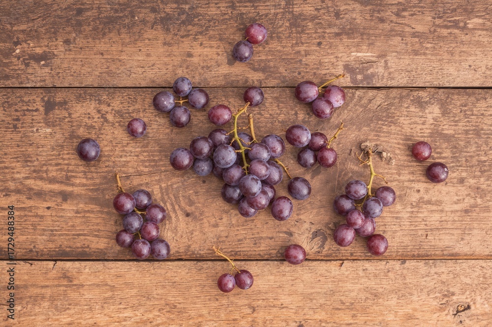 Obraz premium Newly picked grapes on a rustic wooden surface