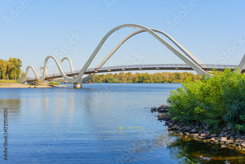 Stunning Wave Pedestrian Bridge Over Serene Waters in Kyiv Showcasing Modern Architecture