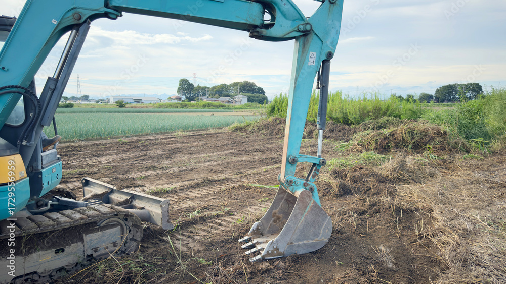 Obraz premium 放置農地の畑をユンボで整備