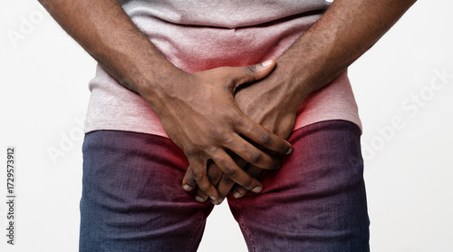 Slika na platnu Afro man covering his genitals with both hands, cropped, sexual diseases concept