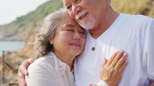 Happy Asian family senior couple enjoy outdoor lifestyle travel nature ocean relaxing together at tropical island beach on summer holiday vacation. Elderly people healthcare and wellness concept.
