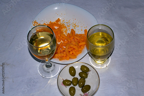 Glass of whote wine and olives , on the table  