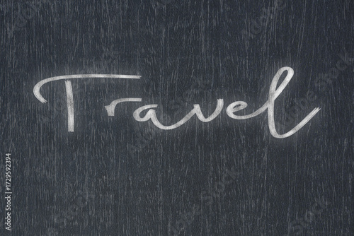 A blackboard with a handwritten chalk message that says travel, a powerful symbol of business success and motivation in educational and production concepts.