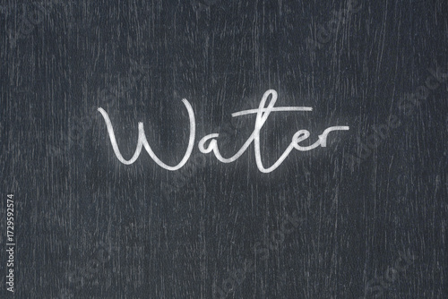 A blackboard with a handwritten chalk message that says water, a powerful symbol of business success and motivation in educational and production concepts.