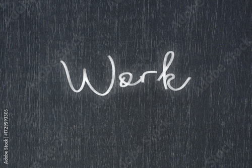 A blackboard with a handwritten chalk message that says work, a powerful symbol of business success and motivation in educational and production concepts.