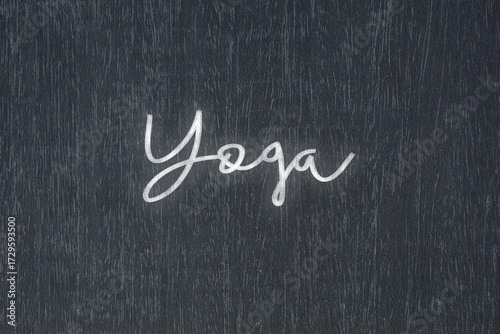 A blackboard with a handwritten chalk message that says yoga, a powerful symbol of business success and motivation in educational and production concepts.