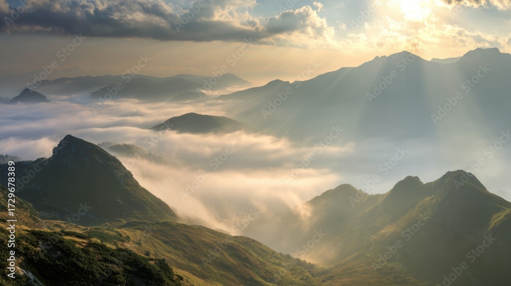 Obraz premium Rolling mountains shrouded in misty clouds are kissed by golden sunlight at daybreak