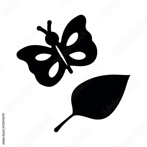 Simple black silhouette of a butterfly fluttering near a fallen leaf
