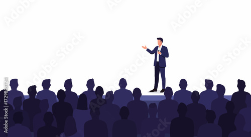 A businessman in a suit stands on stage, giving a presentation to a large, silhouetted audience at a conference.