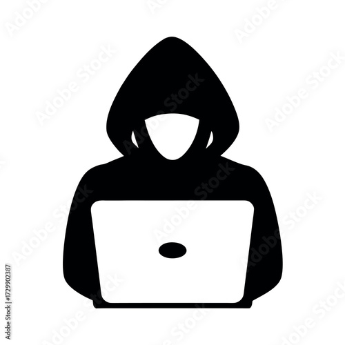Anonymous hacker in a black hoodie using a laptop computer for cybercrime and digital security threats