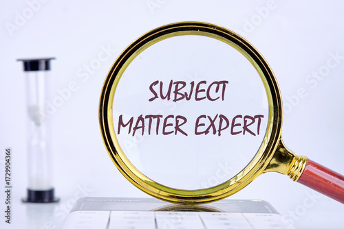 Text Subject Matter Expert written through a magnifying glass on a gray background. Business concept