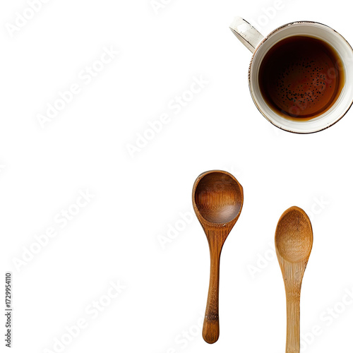 A top-down view of a cup of tea and two wooden spoons on a dark background