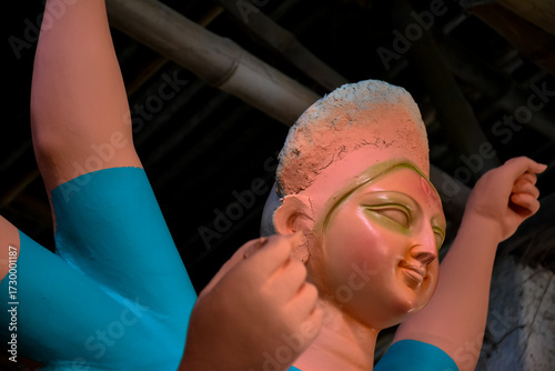 An artiest has been drawing and painting eyes of goddess Durga. Clay idol of Hindu goddess Durga is under preparation.