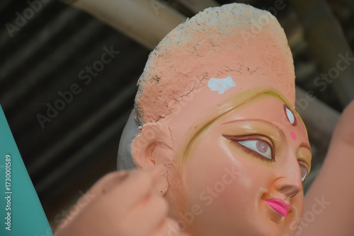 An artiest has been drawing and painting eyes of goddess Durga. Clay idol of Hindu goddess Durga is under preparation.