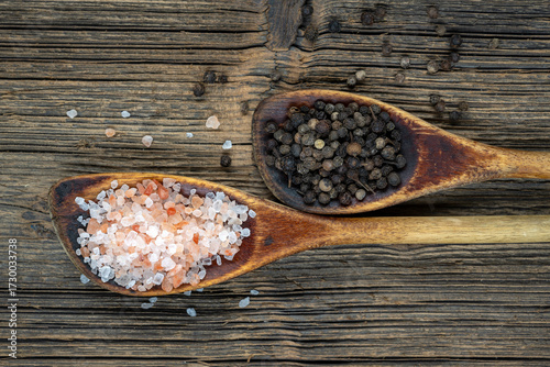 Old wooden spoons with coarse salt and black peppercorns